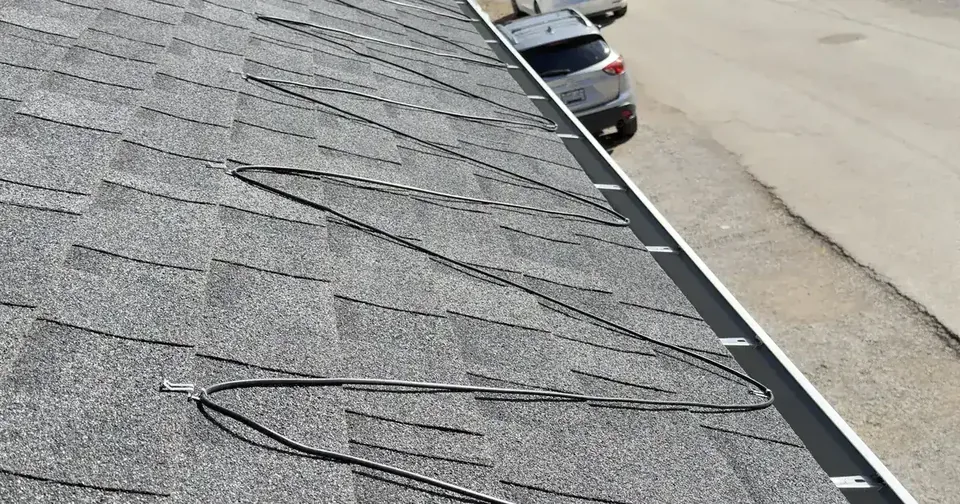 Heating cable arranged across the lower edge of a shingled roof