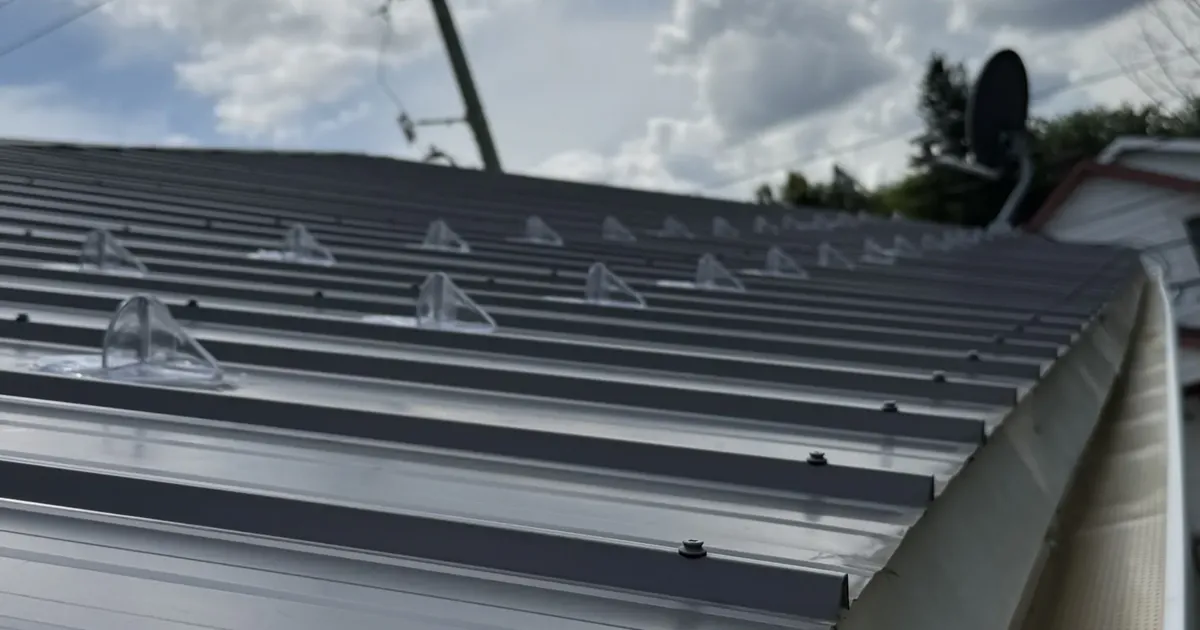 Snow retention pieces mounted in rows on a standing-seam metal roof